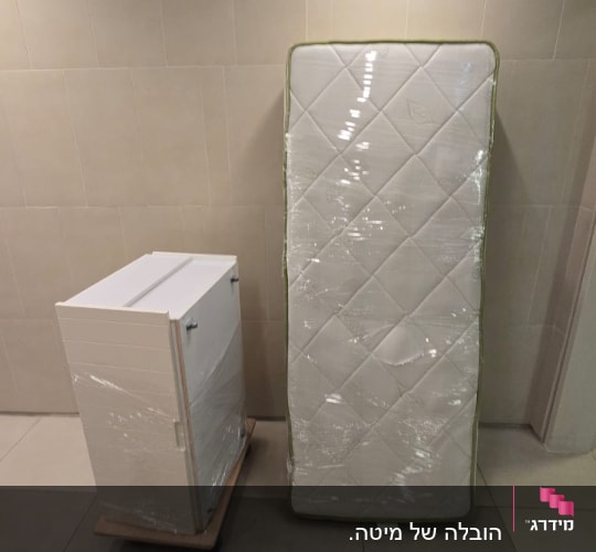 מזרן וארונית לבנה עטופים בניילון נצמד מוכנים להובלה